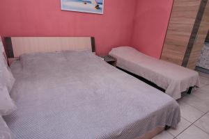 敖德萨Guest house VadLen的一间卧室设有两张床和粉红色的墙壁