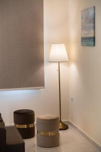 奈德里Bounatsa Studios & Apartments的一间带灯和两张凳子的客厅