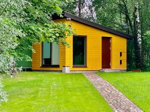 马里扬泊列Marijampole Camping的前面有草坪的黄色房子