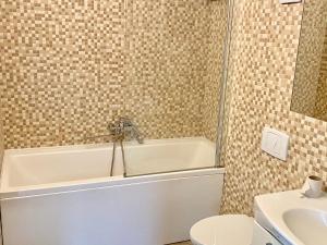马里扬泊列Marijampole Camping的带浴缸、卫生间和盥洗盆的浴室