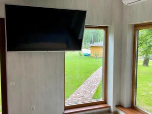 马里扬泊列Marijampole Camping的挂在墙上的平板电视,设有2扇窗户