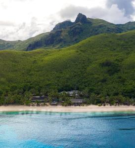 Nalauwaki章鱼度假酒店的享有海滩美景,背景为群山