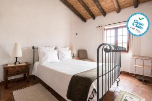 莫托拉Horta da Quinta的白色的卧室设有床和窗户