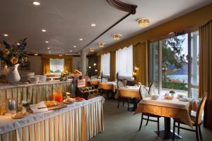 莫尔韦诺Hotel Miralago Wellness - Adults Only的一间餐厅配有桌椅,提供食物
