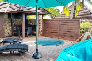 帕佩托艾Villa Anuanua by Tahiti Homes的一个带遮阳伞和游泳池的庭院