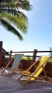 帕佩托艾Villa Anuanua by Tahiti Homes的两把椅子坐在棕榈树甲板上