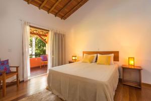阿拉亚尔达茹达Charm Bahia Residencias的一间卧室配有一张带黄色枕头的床
