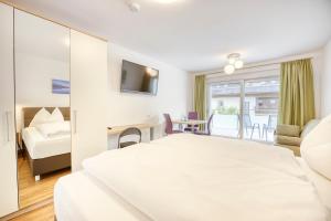 法克湖畔杜罗博拉赫Ferienwohnungen Petschnig 1的酒店客房设有一张白色大床和一间客厅。