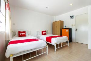 华欣OYO 908 Sabai Place的客房内的两张床,配有红色和白色床单