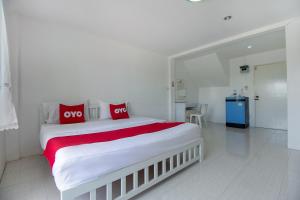 华欣OYO 908 Sabai Place的白色卧室配有一张带红色枕头的大床