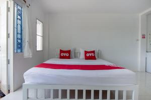 华欣OYO 908 Sabai Place的一张大白色的床,上面有两个红色枕头