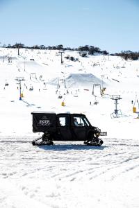 佩里舍峡谷艾格酒店的雪地车停在滑雪场的雪地里