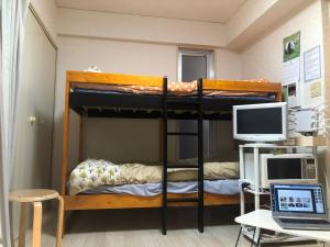 福冈Cocone house Ohoripark的客房设有两张双层床、电脑和书桌。
