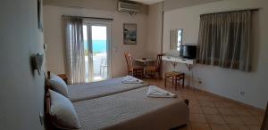 阿齐亚·佩拉加·基西拉佩拉吉亚海滩一室公寓酒店的酒店客房设有两张床和一张桌子,并设有一个阳台。