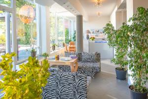 尤斯托尼莫斯基Murena Hotel i Restauracja的一间种植了植物并配有桌椅的房间