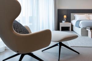 斯利马Waterfront的卧室配有白色椅子和1张床