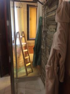 夏卡Guest house La Corte Normanna的浴室设有玻璃淋浴间和梯子