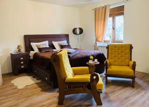 AndrijevicaZvjezdana dolina Garni hotel的一间卧室配有一张床和一张黄色椅子