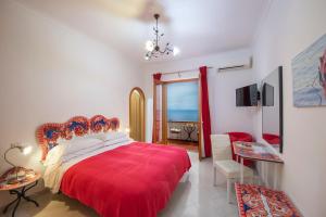 普莱伊亚诺利曼尼花园公寓式酒店的一间卧室配有红色的床和红色毯子