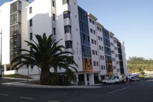 JoveArea Suites的街道前有棕榈树的建筑