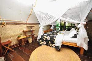 阿鲁沙卡拉马山林小屋的一间卧室配有一张带天蓬的床