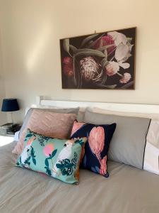 BeechmontLa Dolce Vita的一张带两个枕头的床和墙上的绘画