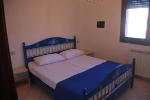 罗索利纳马雷Acquasmeralda appartamento 01的卧室内的一张带两个枕头的蓝色床