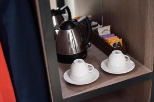 伦敦牛津酒店的一间酒店客房内的架子上的一个茶壶和酱油