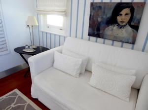 施塔费尔湖畔穆尔瑙Am Eichholz Galerie & Art-Hotel的客厅配有一张白色沙发,配有绘画作品