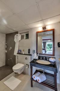 乌提乌蒂德比绿马辛德拉俱乐部酒店的一间带水槽、卫生间和镜子的浴室