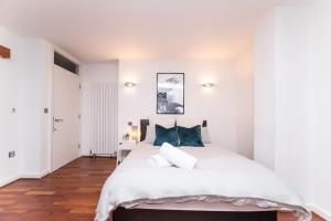 泰恩河畔纽卡斯尔Newcastle Penthouse - Sleeps 8 - City Centre - Free Parking - City Views的白色卧室配有一张带蓝色枕头的大床