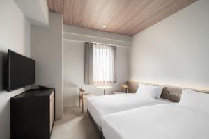 Nest Hotel Hiroshima Ekimae客房内的一张或多张床位