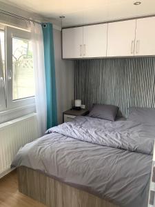 格但斯克Domki nad morzem的一间卧室配有一张带白色橱柜的床和窗户。
