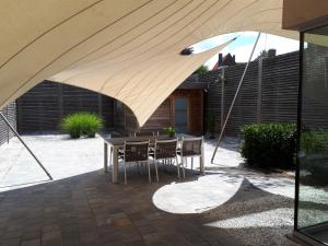 瓦勒海姆Au Paradis Guesthouse的露台配有桌椅和遮阳伞