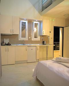 尼基季Sky Rays Luxury Apartments的一间厨房,配有白色的橱柜和一张位于客房内的床