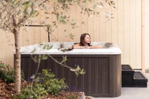 科尔皮缇亚Hotel Berghang的女人坐在浴缸里