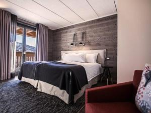 布勒伊-切尔维尼亚拉克雷斯塔木屋酒店的一间卧室配有一张床和一张沙发