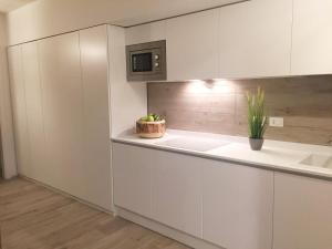 利多迪耶索罗MARINA PONENTE的厨房配有白色橱柜和盆栽植物