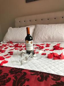 佩尼多Vila Noel Premium的床上坐着一瓶葡萄酒