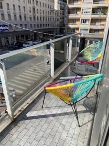 米兰Hotel Stradivari的阳台的椅子和遮阳伞