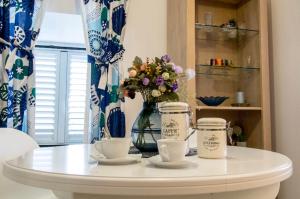 杜布罗夫尼克Apartman Roseta的白色桌子,两杯,花瓶