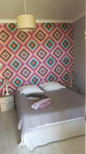 勒托尔fleur de garance的一间卧室设有一张大床和色彩缤纷的墙壁