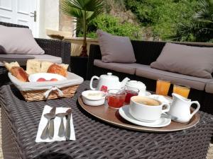 拉卡努尔格Hôtel Le Moulin D'Olt的一张桌子,早餐包括咖啡和烤面包