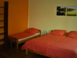 佩茨基Pokoje Przy Kominie的一间卧室配有两张带红色床单和椅子的床