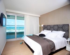 阿什杜德West All Suites Hotel Ashdod的一间卧室设有一张大床和一个大窗户