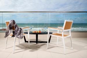 阿什杜德West All Suites Hotel Ashdod的一间带一张桌子和两把椅子的海景用餐室