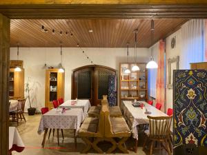 施皮格劳Pension Waldblick的一间设有两张桌子和红色椅子的用餐室