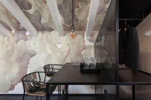 特伦托Casa Trentini - Atemporary Art Apartments的一间墙上配有桌椅的用餐室