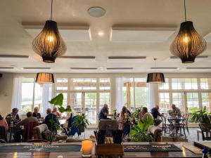 彭特派因卡斯特维诺福克岛酒店的坐在带大窗户的餐厅桌子上的人