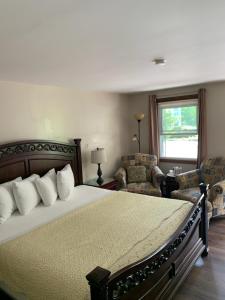 威廉斯敦Stay Berkshires的一间卧室配有一张床、两把椅子和一个窗户